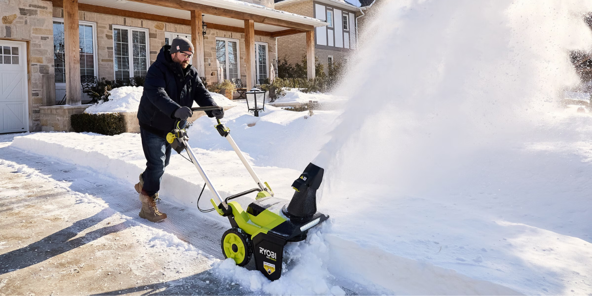 Mann som måker oppkjørselen ved bruk av en snøfreser fra Ryobi.