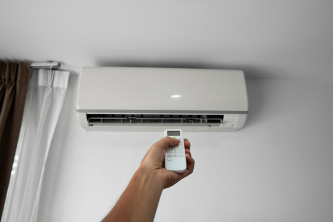 Person som endrer temperaturen med en varmepumpe