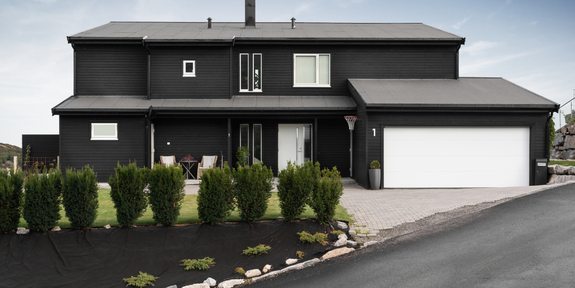 bilde av hageområde med platting og hus med blå vegg