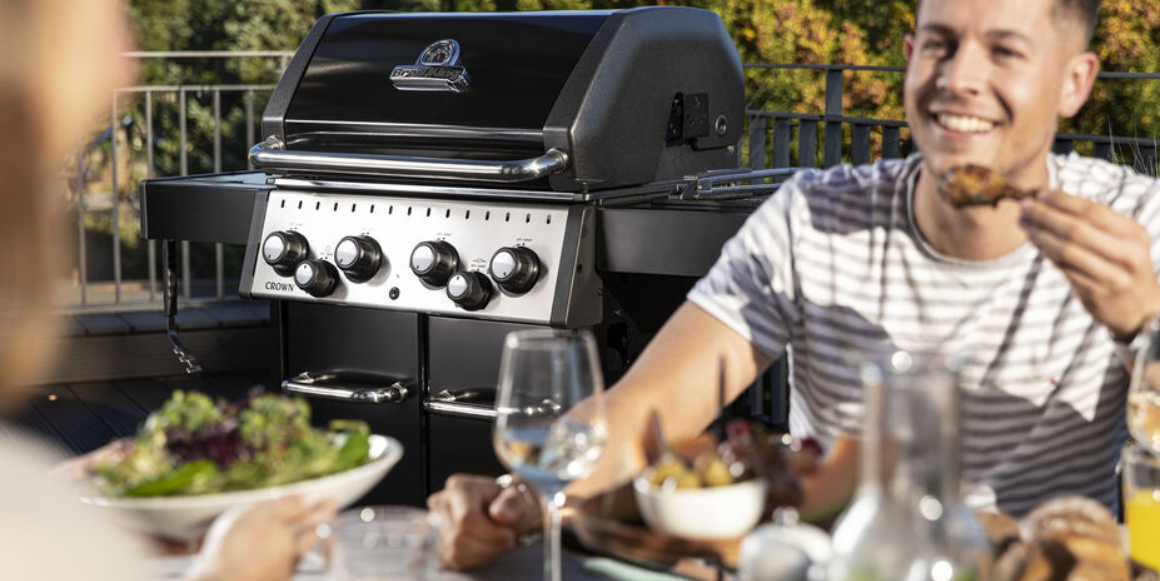 blury mann i front av en broil king grill i modell crown