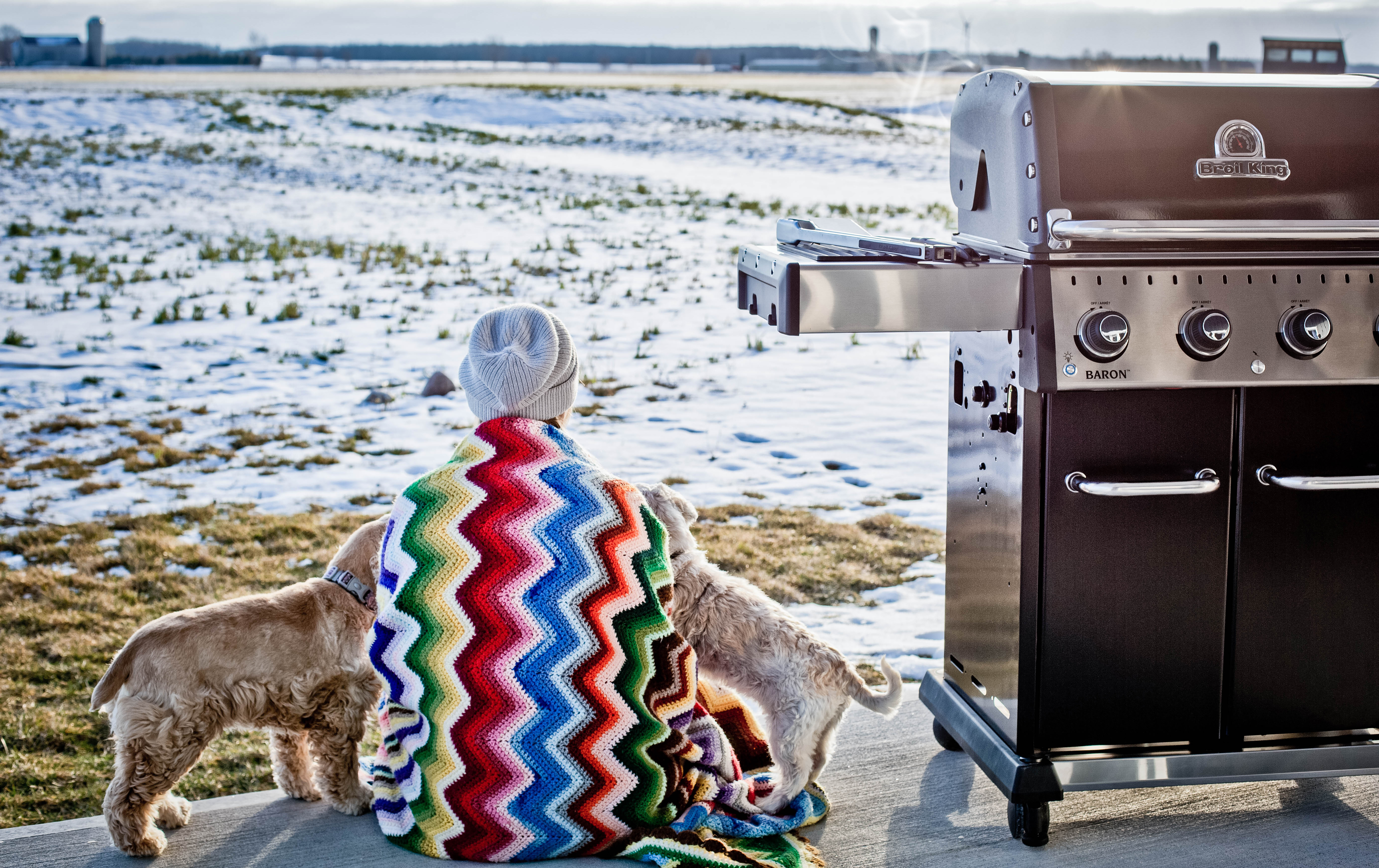 Bilde av kvinne, hund og grill om vinteren