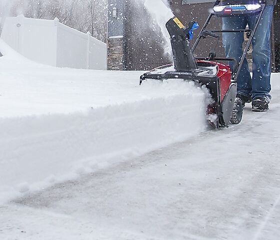 Bilde av en batteridrevet snøfreser, som freser snø.
