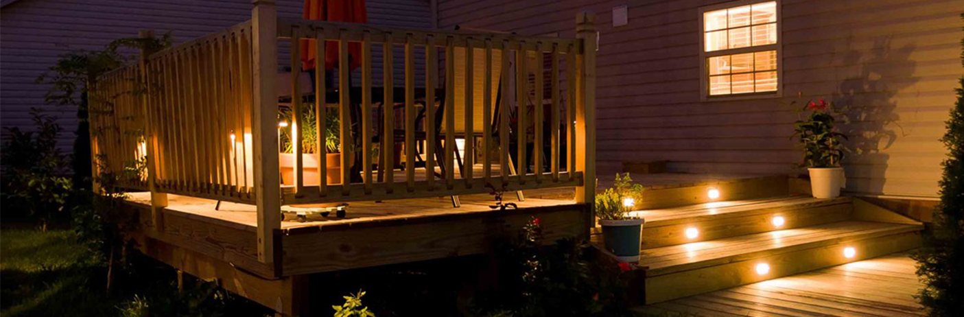 Bilde av en terrasse på kveldstid, med utebelysning.