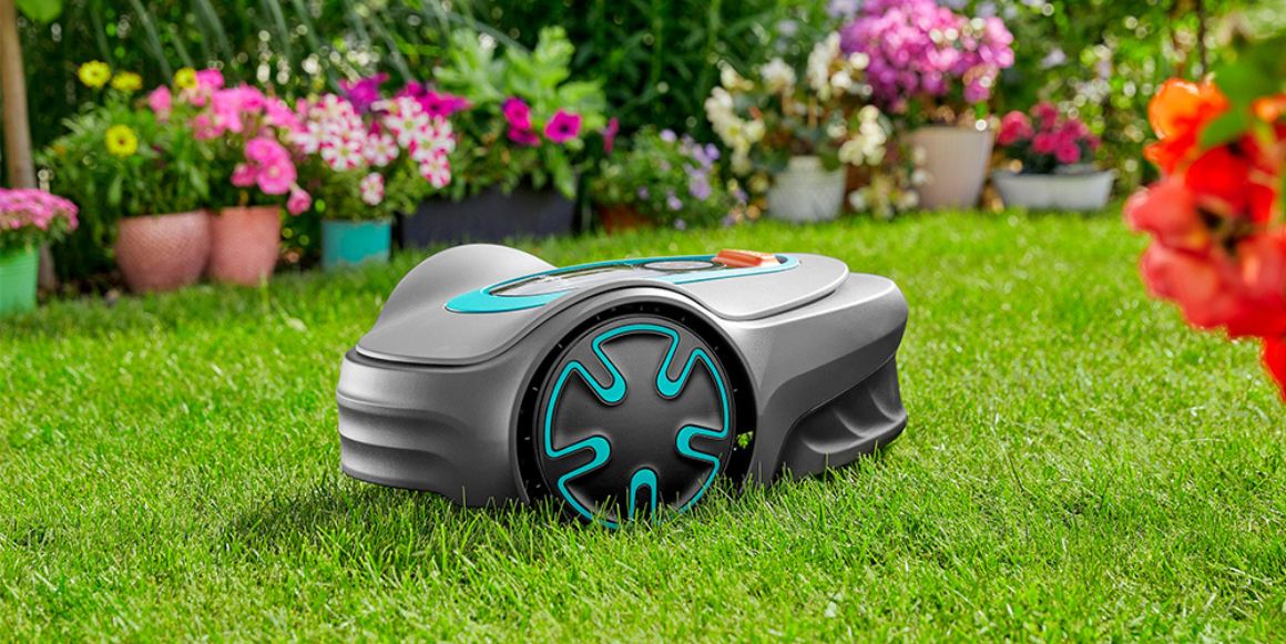 robotgressklipper fra gardena på plen i hage full av blomster