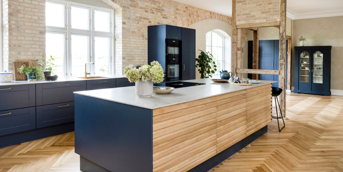 Med en kjøkkenøy med koketopp og nedtrekk, samt veggmontert komfyr og vaskesone, opprettholdes arbeidstrekanten og sikrer optimale arbeidsforhold. På bildet ser du Nordic kjøkken fra danske Aubo i fargen Royal Blue.