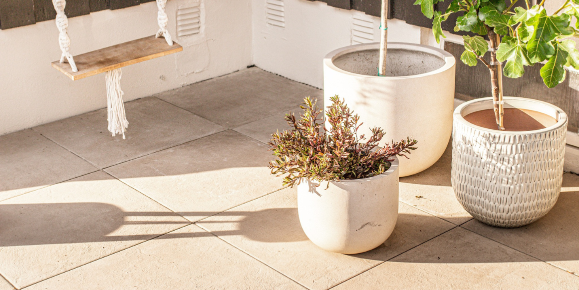 uteplas med heller fra Aaltvedt og en rekke blomsterpotter med buskevekster i