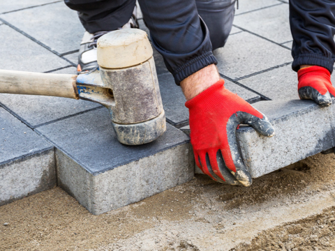 Mann som legger belegningsstein i oppkjørsel Mann som legger belegningsstein i oppkjørsel