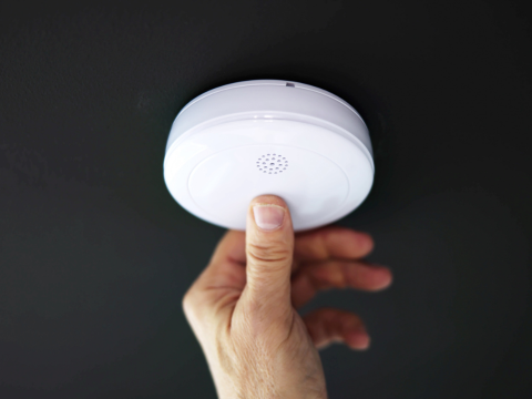 Test av røykvarsler Hånd som tester om røykvarsleren funker