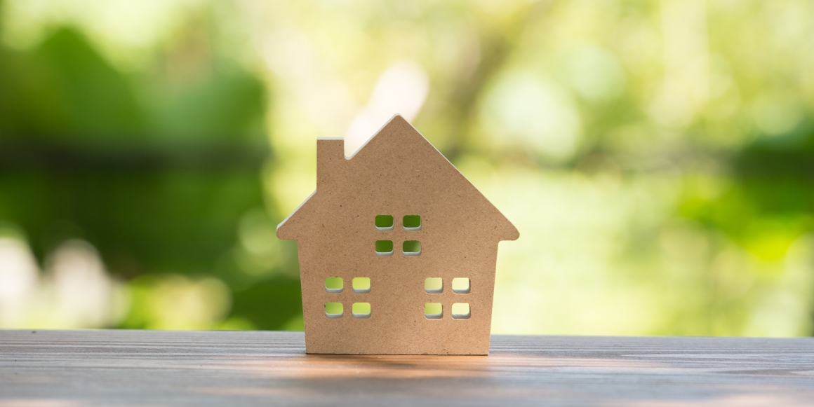 Trehus med grønn bakgrunn som symboliserer grønne boliglån