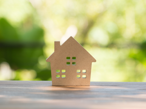 Trehus foran grønn bakgrunn som demonstrerer grønne lån