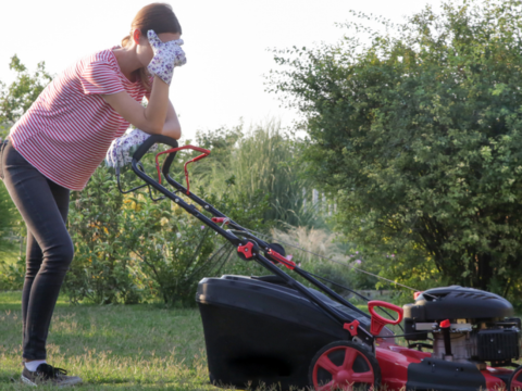 dame som står bøyd over en ødelagt gressklipper dame som står bøyd over en ødelagt gressklipper