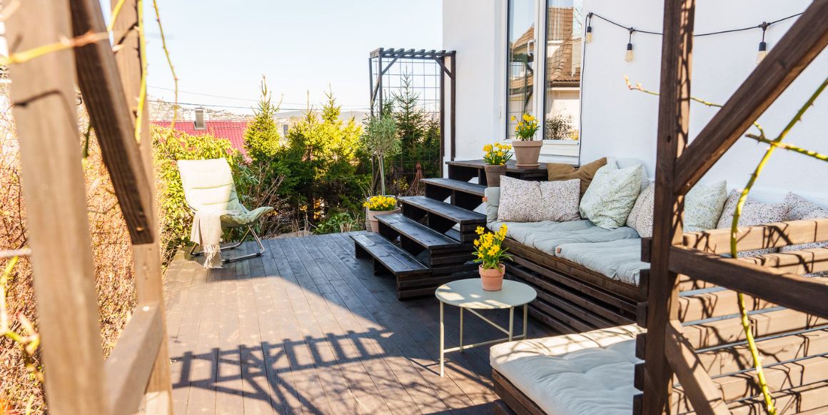 Nybeiset terrasse med blomster og hagemøbler