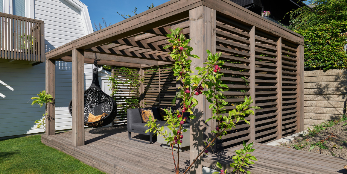 Pergola med sittegruppe og planter i front