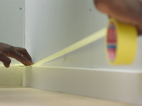 mann som maskerer veggen innendørs før maling mann som maskerer veggen innendørs før maling