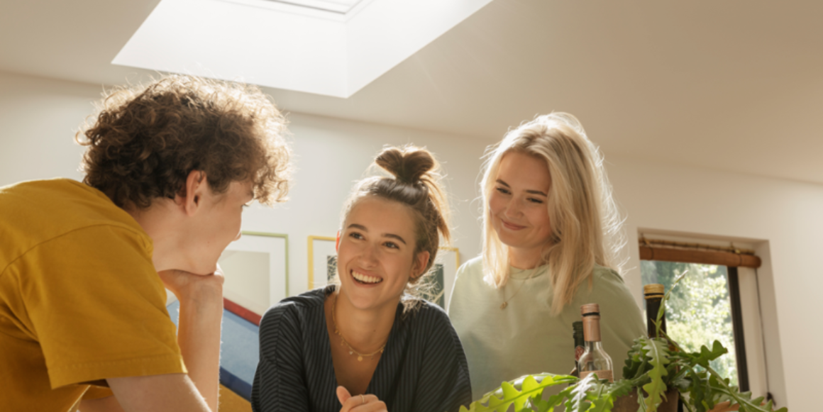 To kvinner og en mann under et vindu installert i et flatt tak